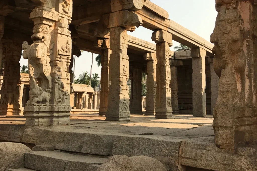 A close-up shot of weathered, detailed stone sculptures and relief panels on the exterior walls of an ancient Indian temple.