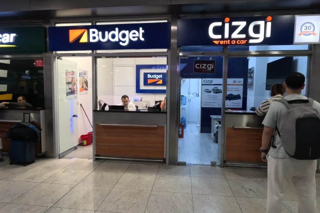 The storefront and reception desk of the Cizgi car rental agency located inside the airport terminal.