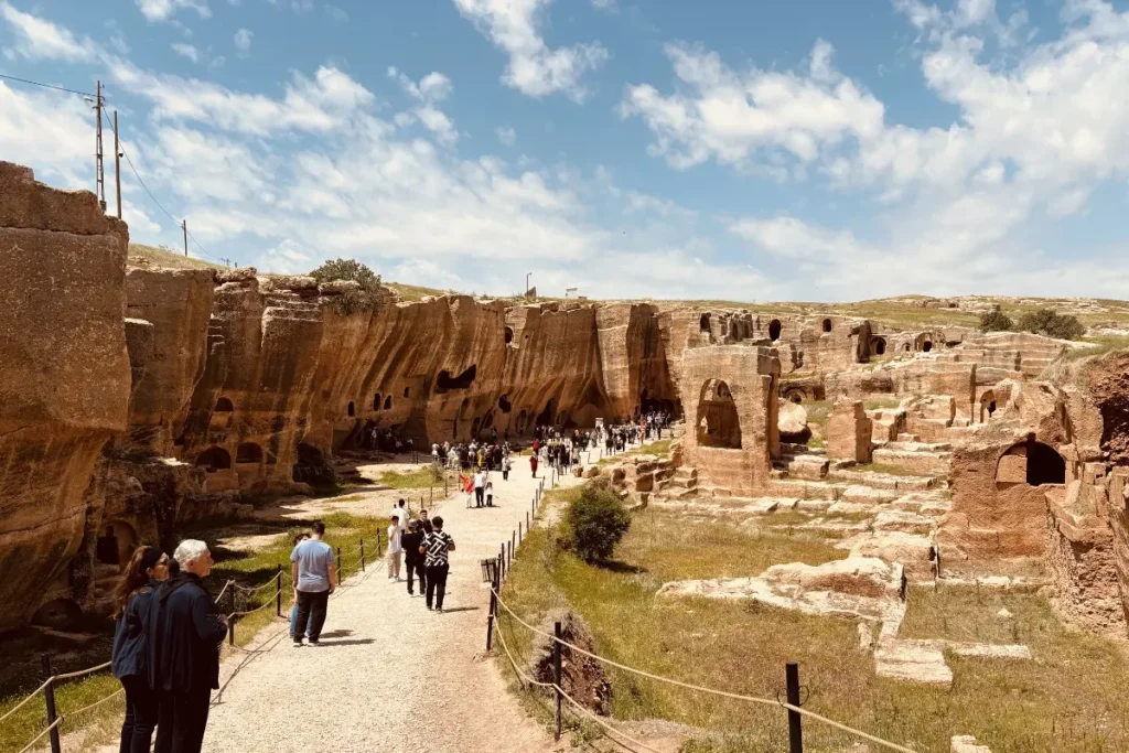 The extensive rock-cut ruins, arches, and ancient structures of the Dara Mesopotamian ruins under a hazy blue sky.