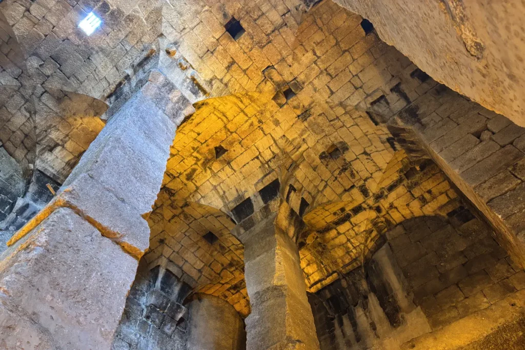 Large, ancient stone pillars and arches supporting the underground water cistern in Dara.
