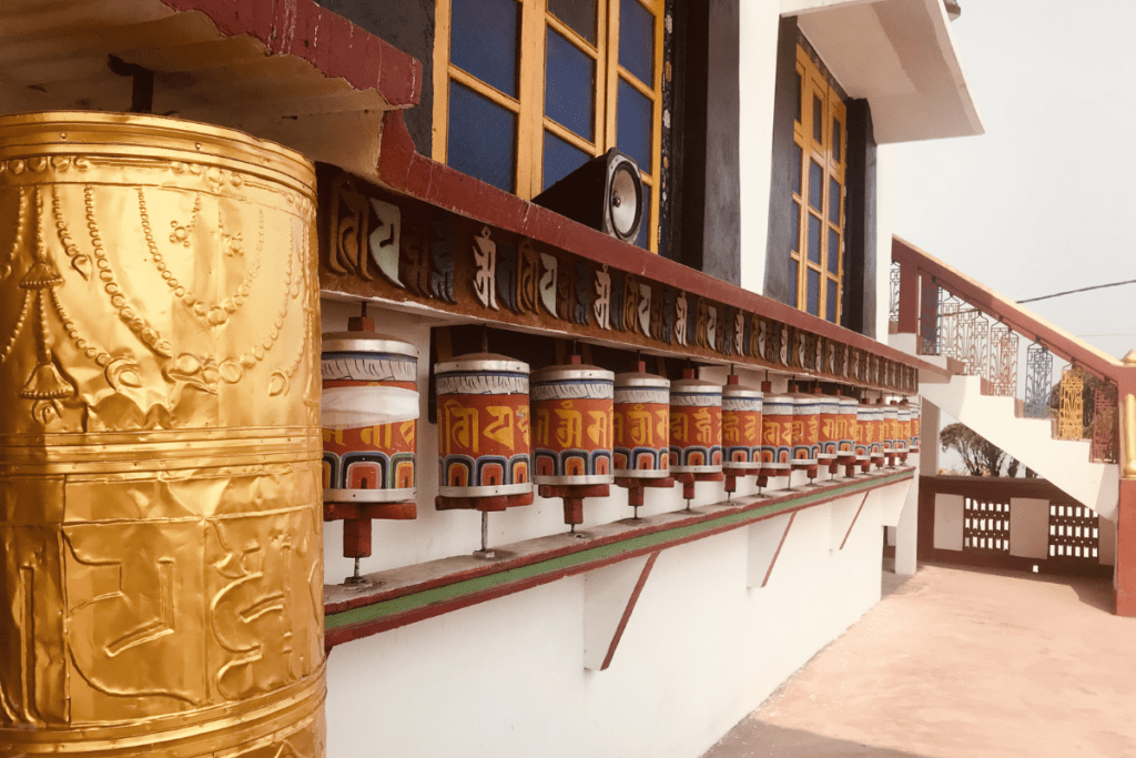 Row of prayer bells at a Buddhist monastery in Gangtok Sikkim with mountain backdrop