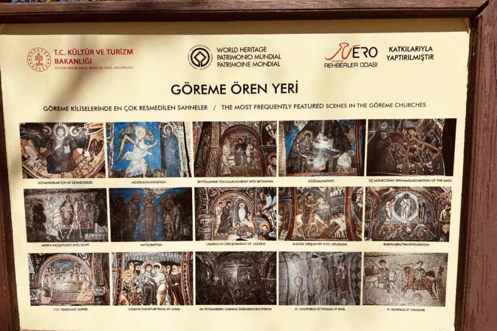 A large informational metal sign board at the Göreme Open Air Museum containing multiple cave churches with their interior views.