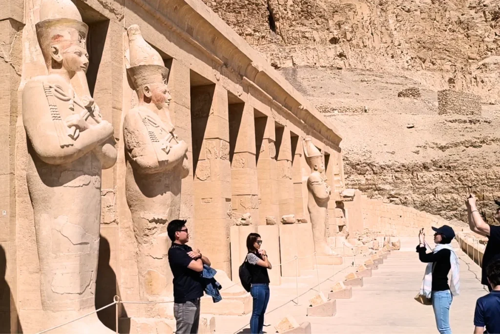 People standing and posing in front of the statues at Hatshepsut Temple