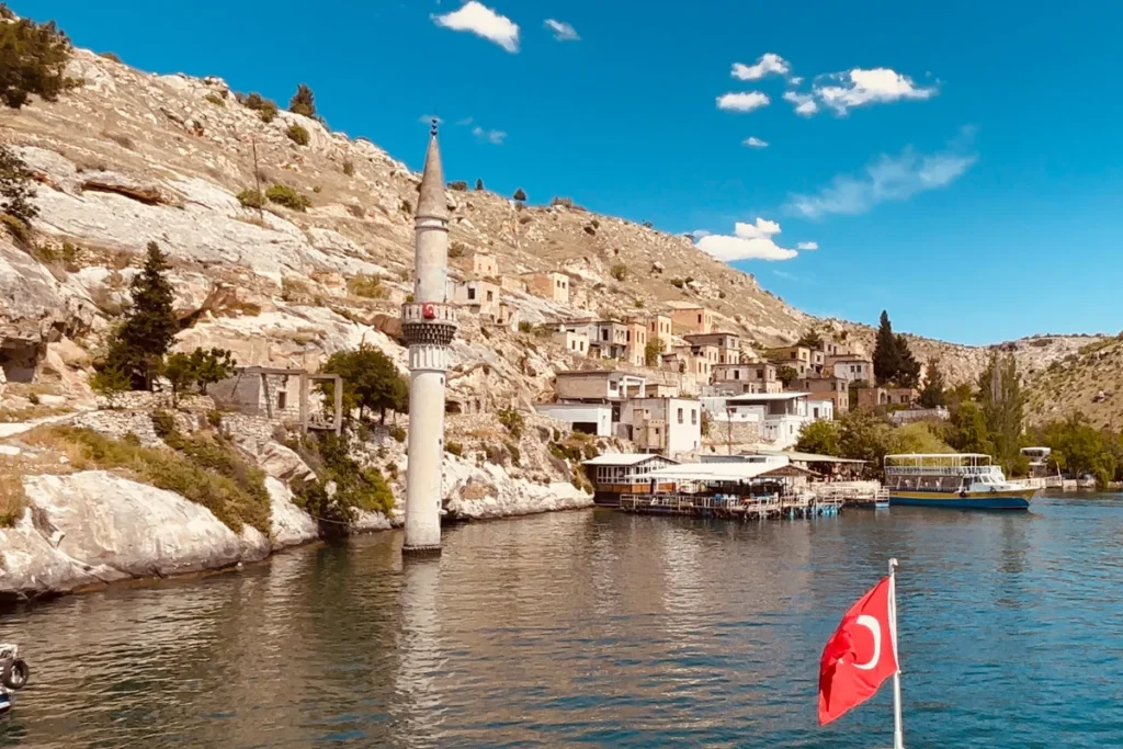 A lone stone minaret of a submerged mosque rising directly out of the deep green waters of the Euphrates River in Halfeti.