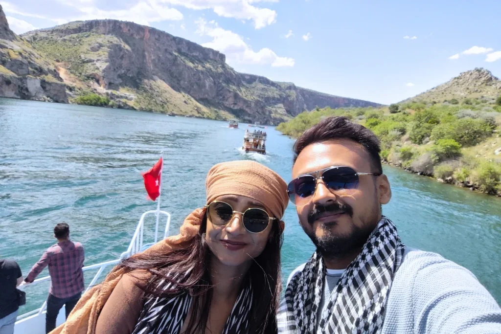 A close-up selfie of Akash & Sumana together while on a boat trip along the water.