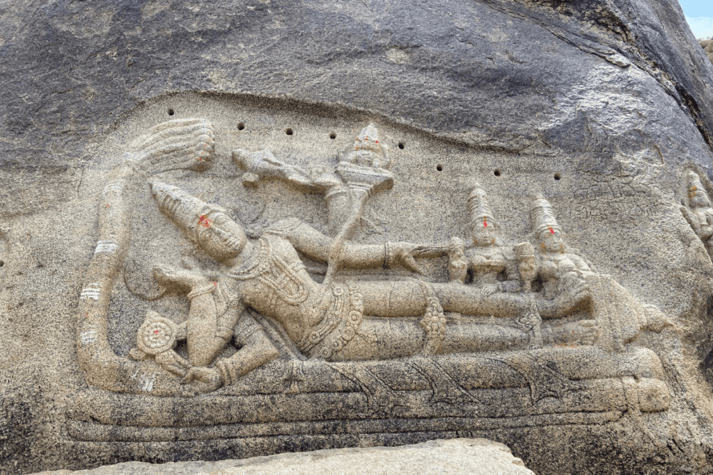 Ancient carving of Lord Vishnu etched into riverside boulders at Hampi Karnataka
