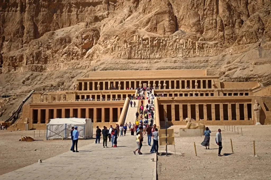 The multi-tiered colonnaded terraces of Hatshepsut Temple built into a massive limestone cliff face.