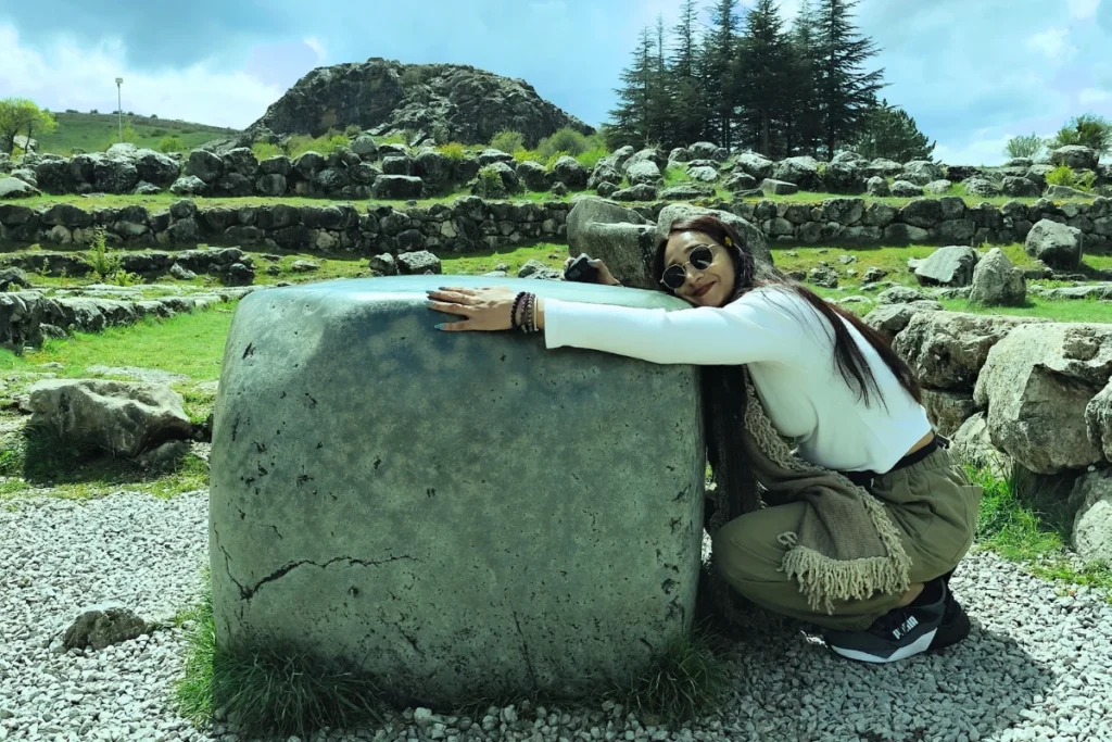 A large, rectangular block of smooth green nephrite stone, known as the green wish stone, resting among the ruins of Hattusa.