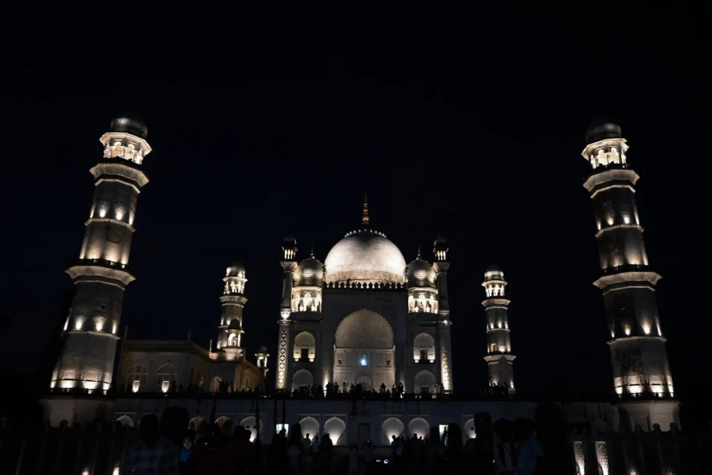 India (1) A symmetrical night view of the illuminated Bibi Ka Maqbara in Chhatrapati Sambhajinagar, Maharashtra, showcasing its central marble dome and flanking minarets glowing under dark skies.