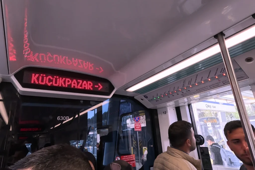Interior shot looking down a modern, brightly lit commuter tram car in Istanbul.