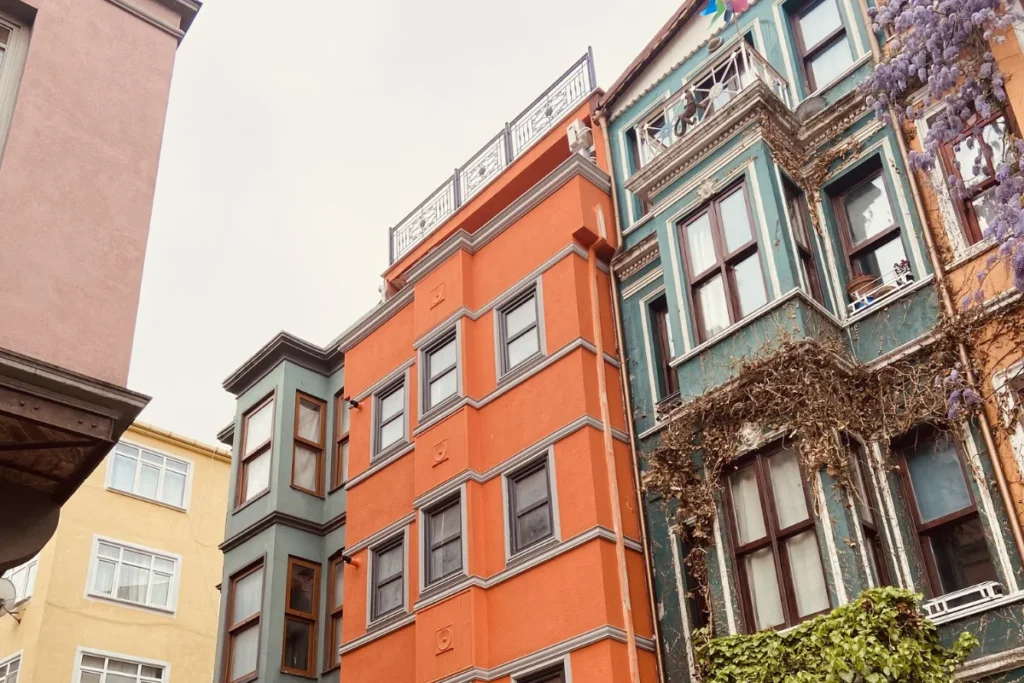 Istanbul- Balat-1 A low-angle shot showing the iconic, brightly painted red and orange historic houses and windows typical of the Balat neighborhood.