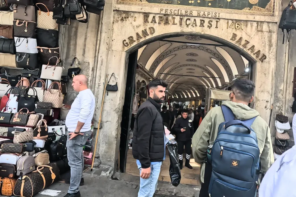 Istanbul- Grand Bazar (2) Shoppers walk down a historic vaulted brick archway corridor inside the busy Grand Bazaar market street.