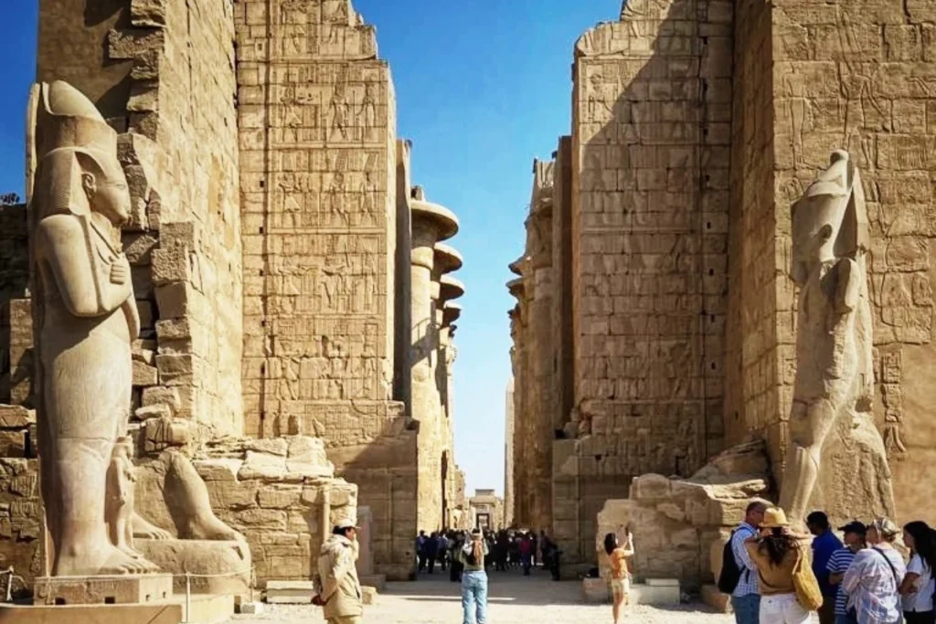  Looking through a dense forest of massive, intricately carved sandstone columns at Karnak Temple.