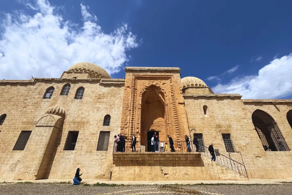 The stone facade and arched entrance of the Kasimiye Madrasa under a blue sky.