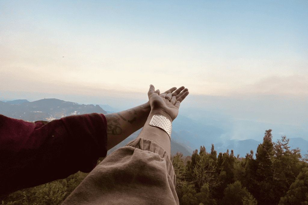 Couple framing Kodaikanal hill landscape with hands travel photography Tamil Nadu