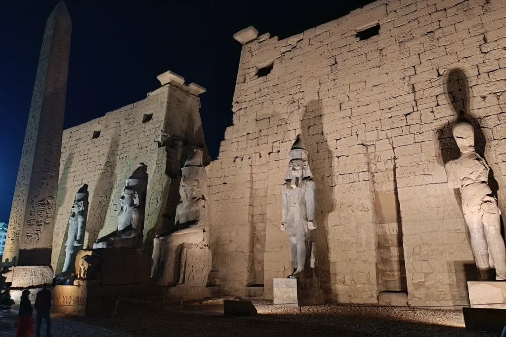 The massive stone entrance pylon and monumental statues at Luxor Temple.
