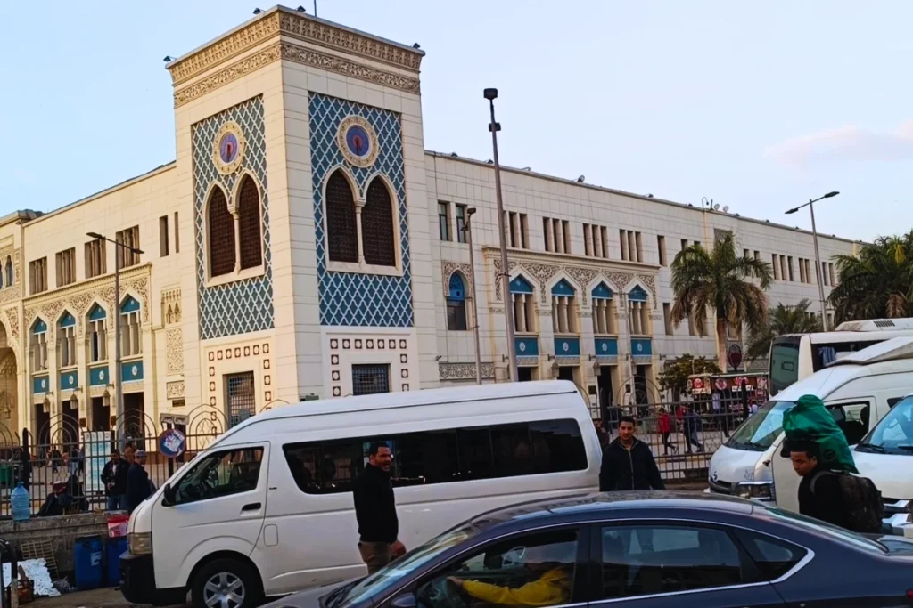  A wide exterior shot of the historic Ramses Station building with classic architectural arches, street traffic, and white vans parked out front.