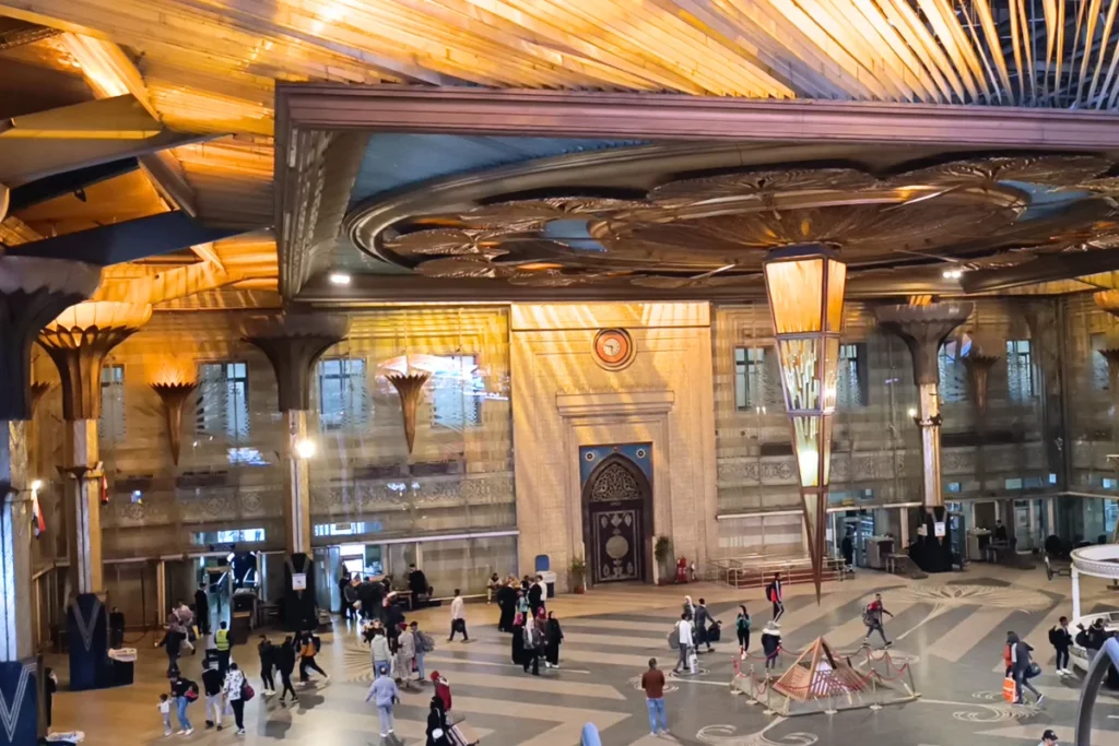 A view of the high-ceilinged grand hall inside Ramses Station, featuring expansive skylights and intricate golden structural details.