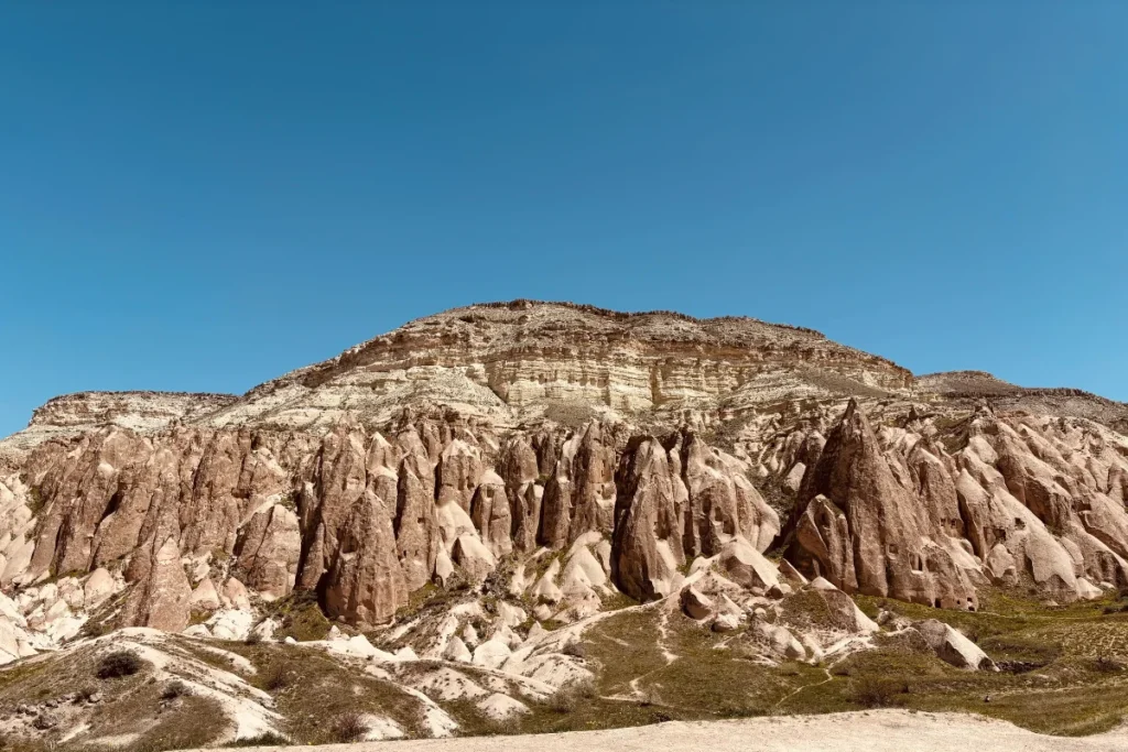 A view of the weathered, smooth, light-colored volcanic rock formations that make up the signature landscape of Cappadocia.