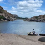Coracle boats resting near the rocky bank of the Tungabhadra River in Hampi.