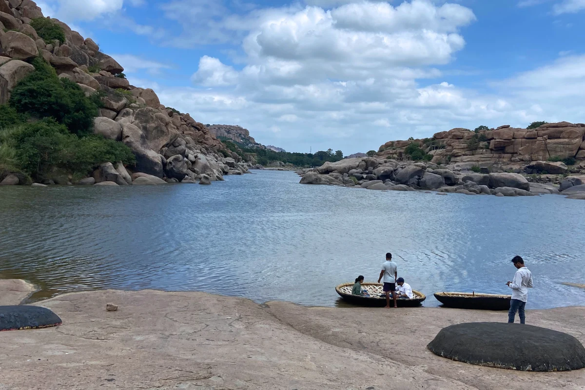 Coracle boats resting near the rocky bank of the Tungabhadra River in Hampi.
