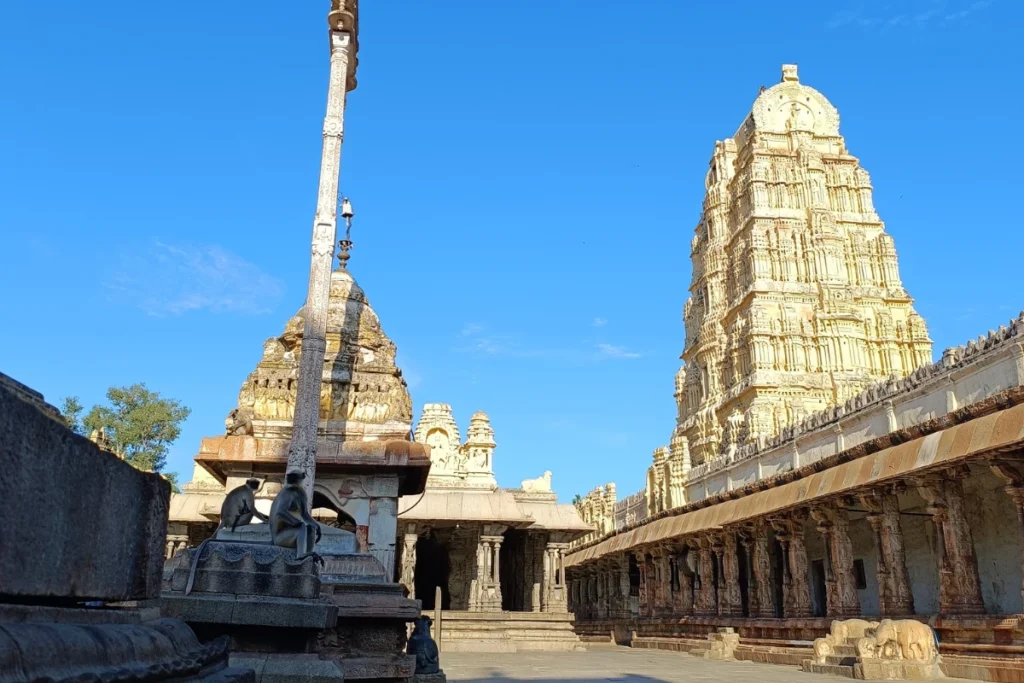 A view inside the inner courtyard of the Virupaksha Temple, showing detailed stone pillars and temple gateways.