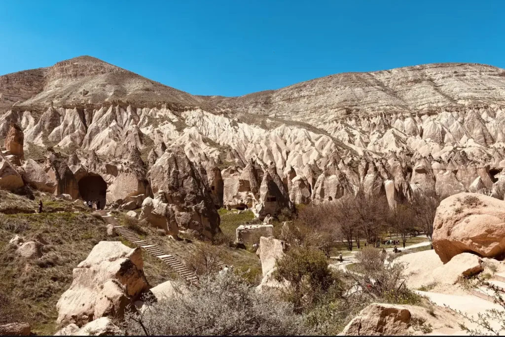 A shot of ancient stone archways and carved pillars seamlessly integrated into the natural rock faces of the valley.