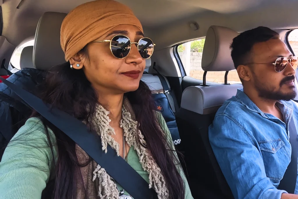 Akash & Sumana inside a car, looking out at the scenery while passing through a mountain pass.