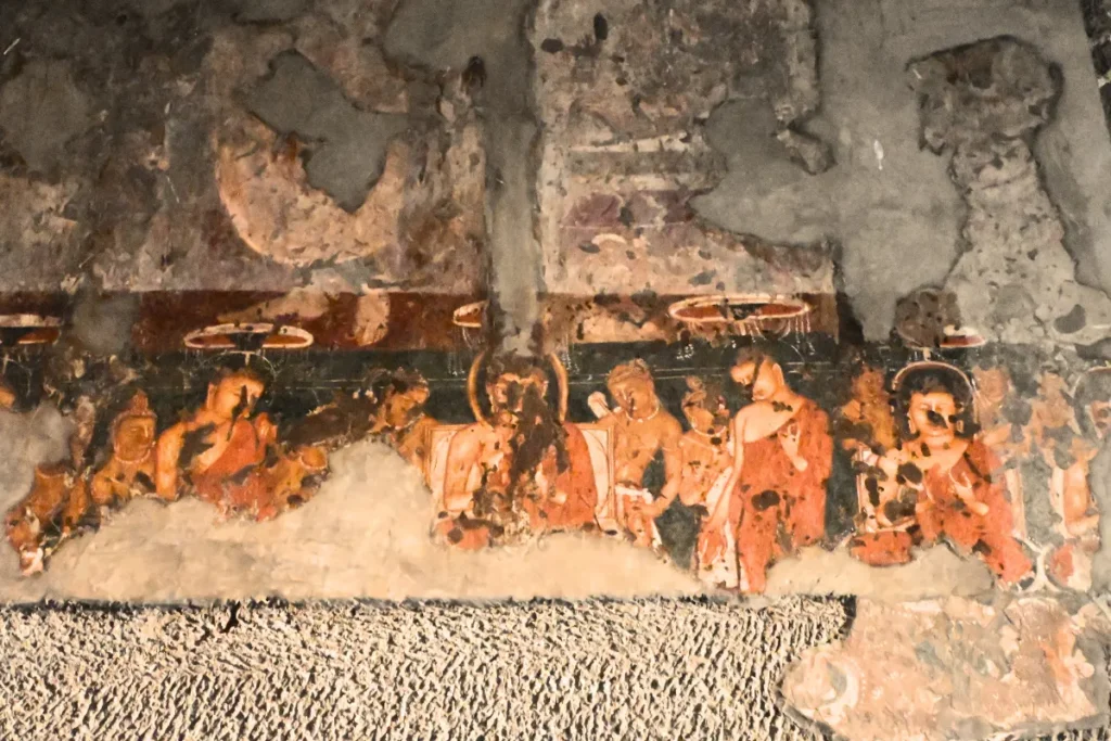 Ajanta Cave 2 A detailed ancient wall mural painting in Cave 2 at Ajanta depicting the Miracle of Sravasti with multiple figures of Buddha surrounded by intricate patterns.
