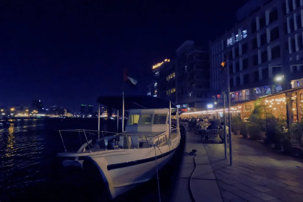 Dubai- creek 2 A nighttime shot of wooden boats moored along the illuminated harbor of Dubai Creek, with city lights reflecting on the water.