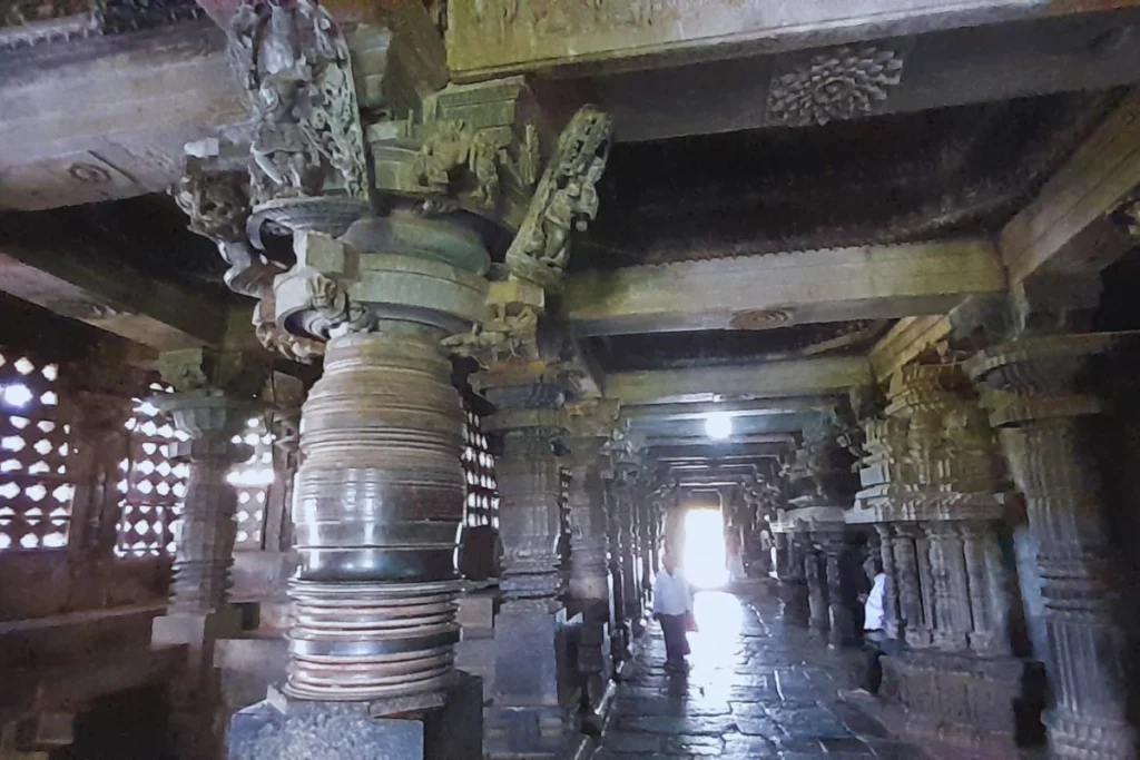 Hoysalaswar Temple 4 An interior view of the temple hall showing smooth, lathe-turned, mirror-like dark stone pillars reflecting ambient light.