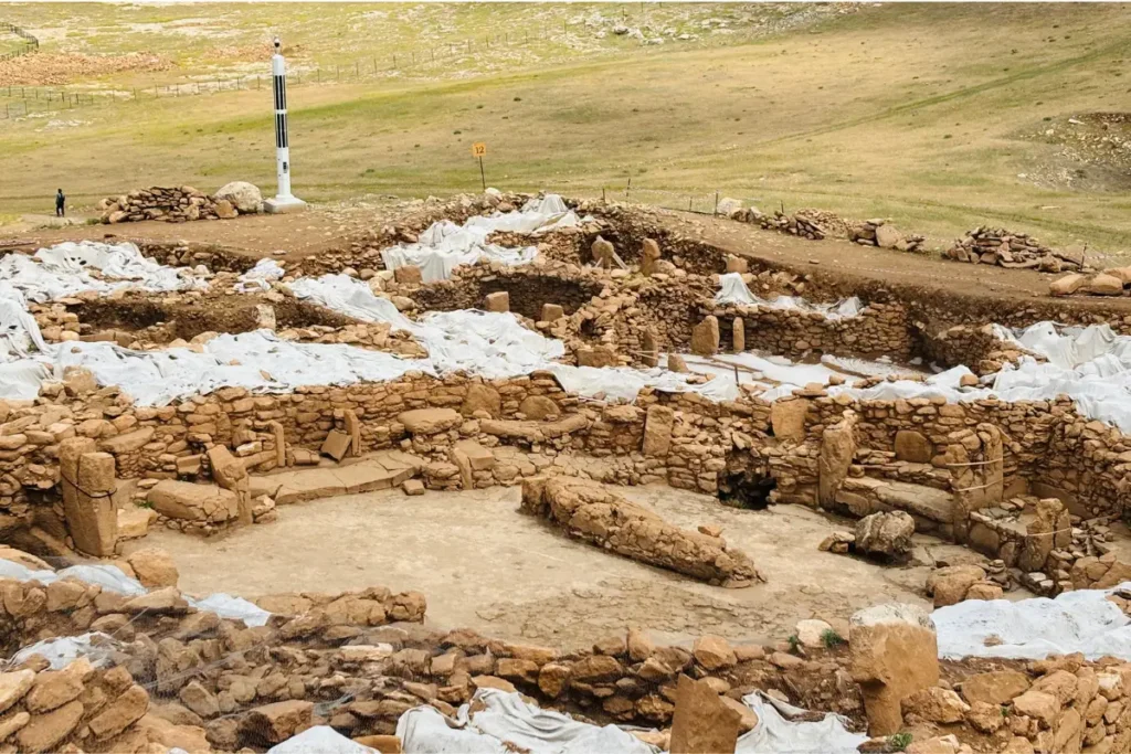 Karahan Tepe 4 A modern color photograph of the active Karahan Tepe archaeological dig site with terraced pits and stone walls.