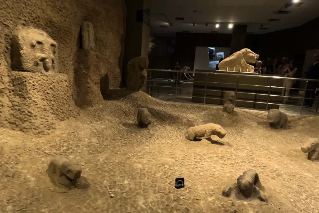 A museum exhibit showing three-dimensional carved animal statues and stone artifacts on display.