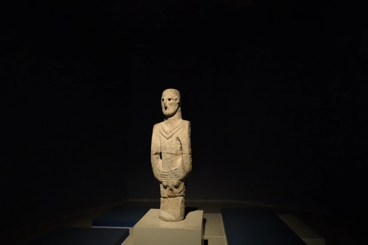 A full-length view of the iconic Urfa Man statue, an ancient limestone sculpture of a human figure with obsidian eyes, standing inside a display case at the museum.