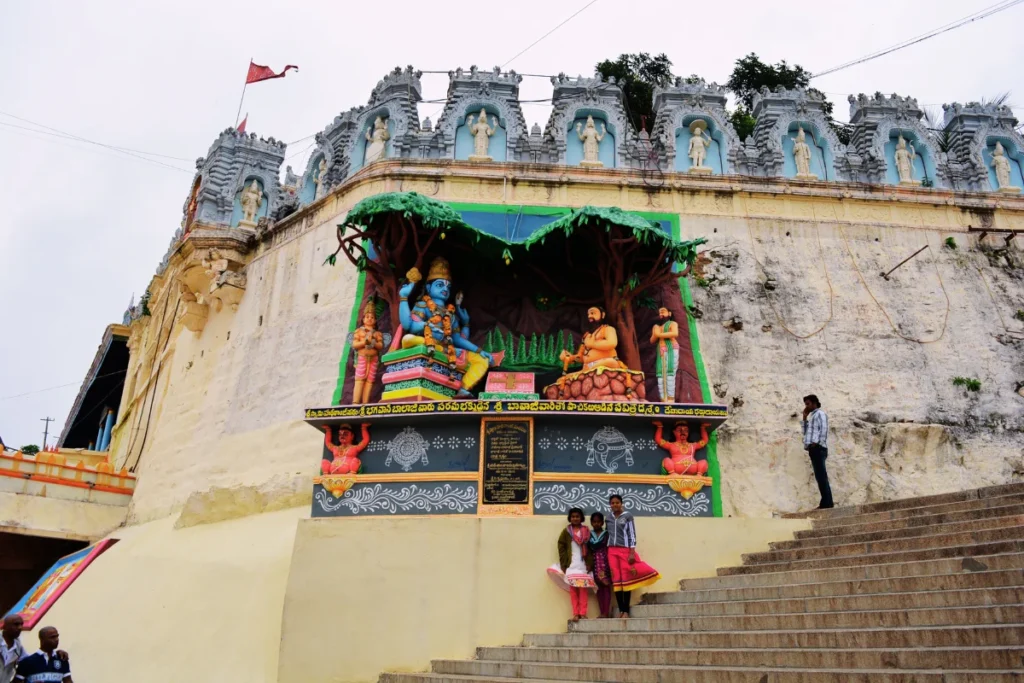 Tirupati- temple complex 2 A highly detailed and brightly painted colorful statue of Lord Vishnu placed within an alcove on a stone structure.
