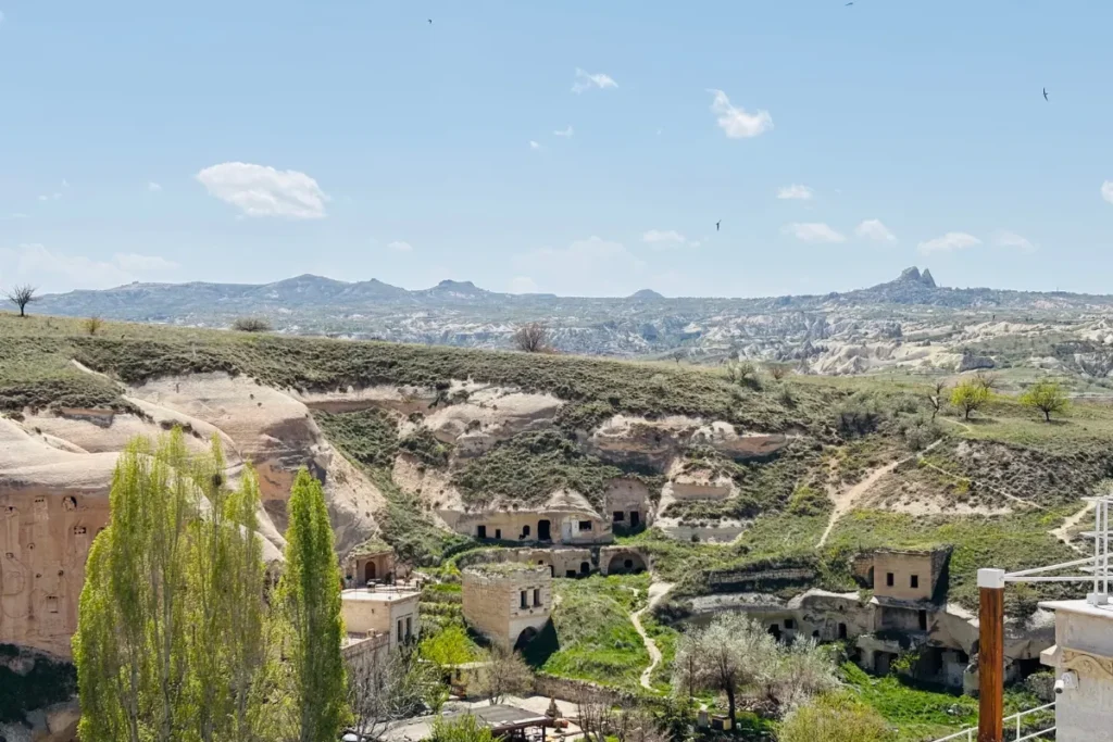 Cavusin 1 An elevated view looking down at the historic stone houses and ancient cliffside ruins of Çavuşin village.