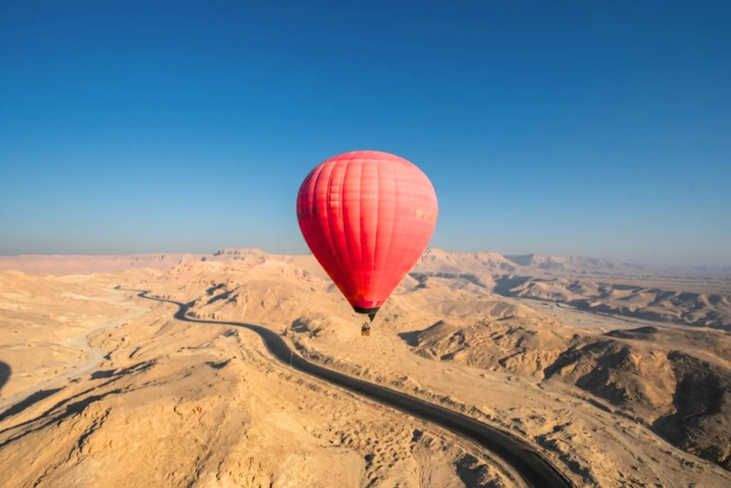 Egypt- Hot Air Balloon 4 High-altitude view from a hot air balloon showing the contrast between green farmland and desert terrain.