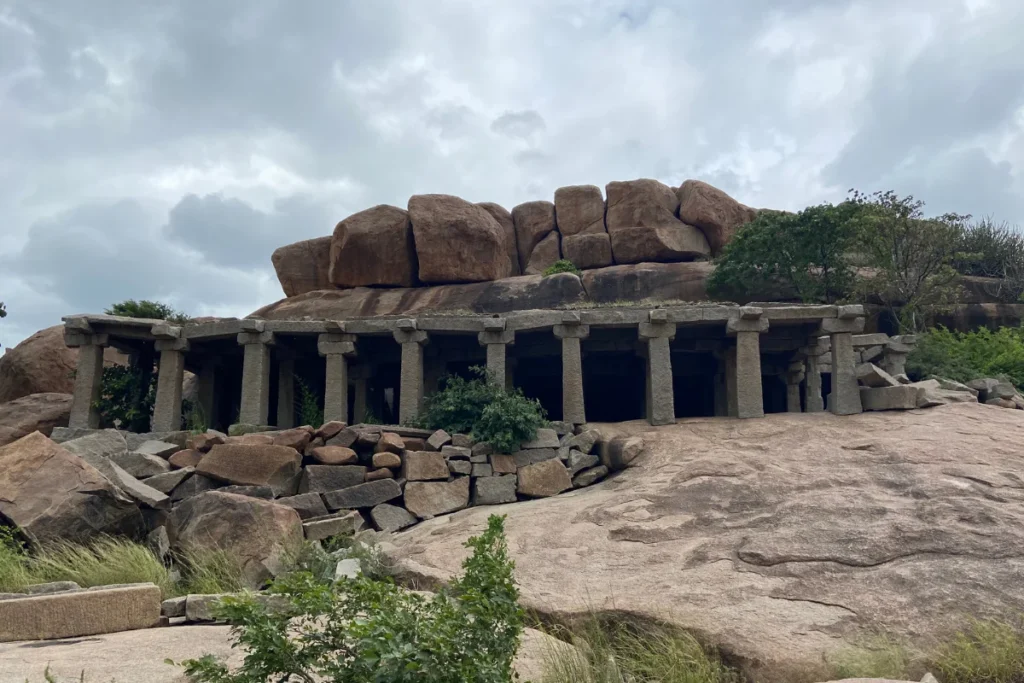 Hampi river side ruins Weathered ancient stone temple pillars and carved structures situated along the rocky banks of the Tungabhadra River.