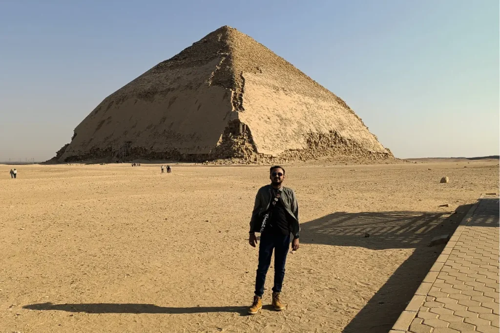 EGYPT- BENT PYRAMID 2 Akash standing in the desert sand with his back to the camera, looking toward the large Bent Pyramid in the background.