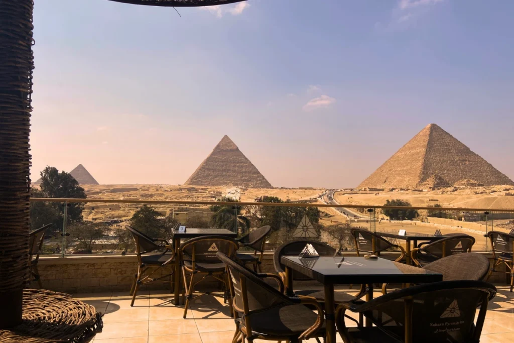 EGYPT- GIZA PYRAMIDS A view of the Pyramids of Giza taken from Sahara Pyramids Inn hotel rooftop terrace with tables and chairs.