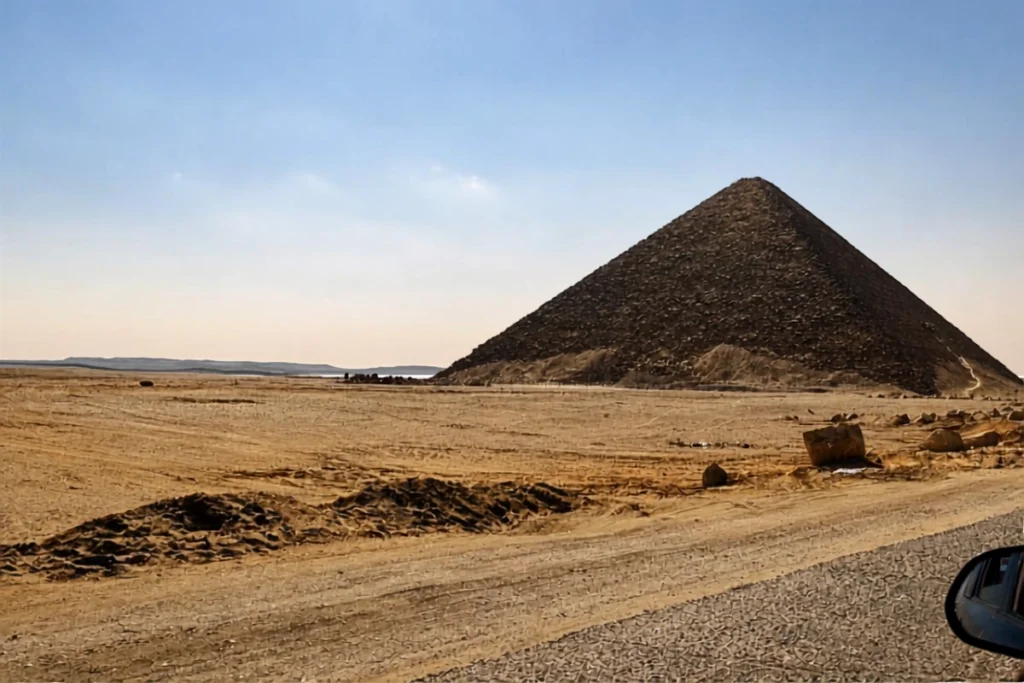 EGYPT- RED PYRAMID Wide view of the large, smooth-sided Red Pyramid standing against a clear blue sky in the desert.