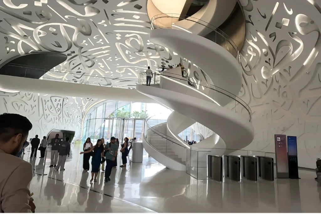 Museum of the future 4 Bright white lobby atrium featuring a large double-helix spiral staircase filled with visitors inside the Museum of the Future.