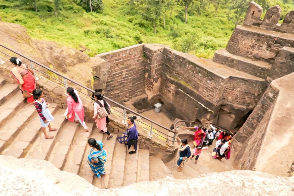 Daulatabad Fort 2 A flight of concrete steps leading out from an underground dark passageway with visitors walking up.