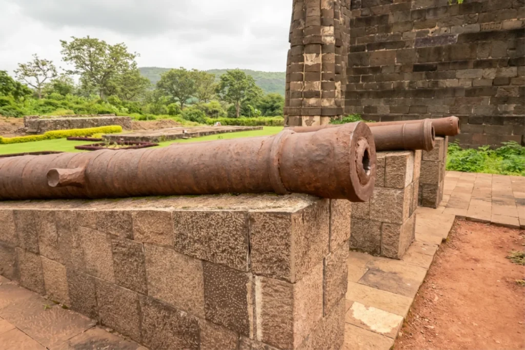 Daulatabad Fort 3 (1) Row of ancient iron cannons resting on stone pedestals along the fort ramparts.