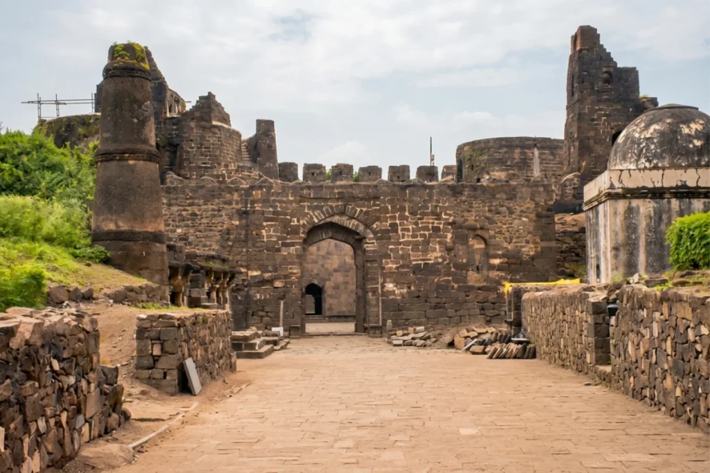Daulatabad Fort 7 Stone archway and ancient fortified walls of Daulatabad Fort surrounded by lush greenery.
