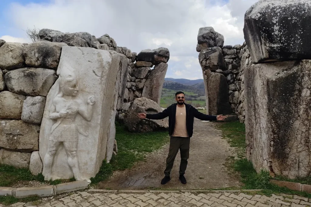 Akash posing in front of a stone replica gate structure at Hattusa.