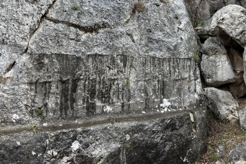 Ancient rock-cut reliefs of deities aligned along the stone walls of the Yazilikaya sanctuary.