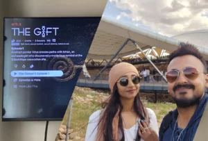 A collage of Akash & Suman's selfie infront of Gobekli Tepe and a TV screen showing "The Gift" series opening episode